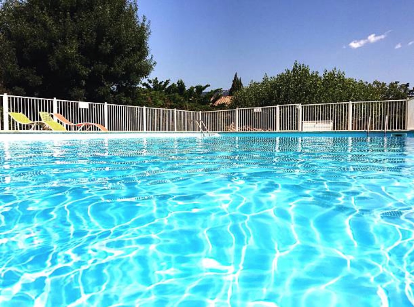 swimming pool with white metal fence installed around perimeter