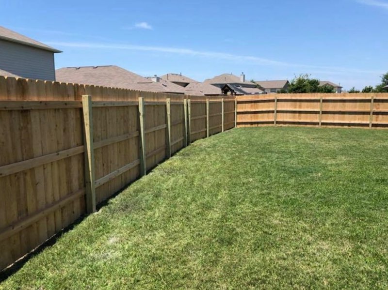 backyard with wood privacy fence dividing homes in neighborhood
